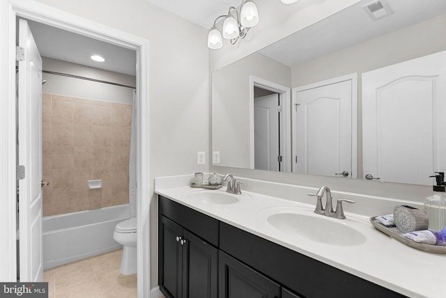 full bathroom featuring toilet, vanity, tile patterned flooring, and tiled shower / bath combo