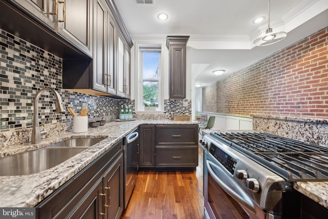 kitchen with light stone counters, sink, dark brown cabinets, and stainless steel appliances