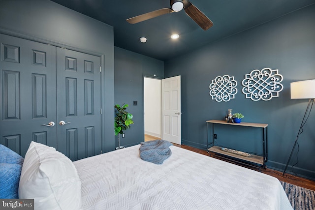 bedroom with ceiling fan, dark hardwood / wood-style floors, and a closet