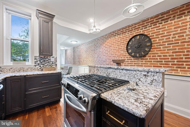 kitchen with pendant lighting, stainless steel range with gas cooktop, crown molding, and dark wood-type flooring