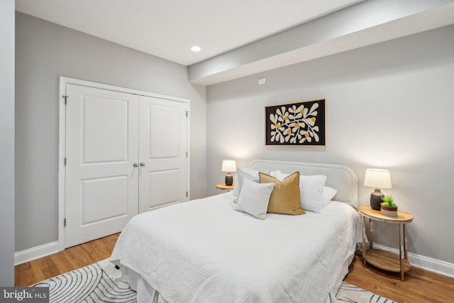 bedroom with light hardwood / wood-style floors and a closet