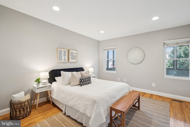 bedroom with multiple windows and light wood-type flooring