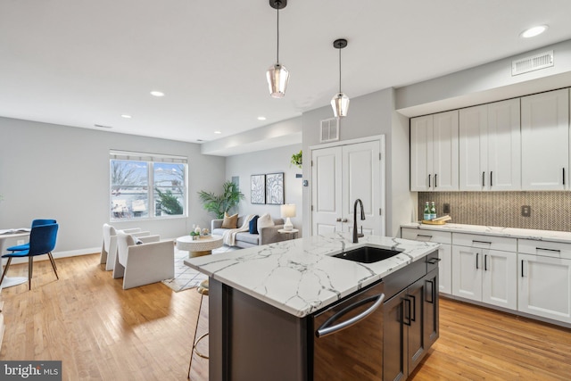 kitchen with white cabinetry, dishwasher, sink, and decorative backsplash