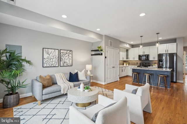 living room with sink and light hardwood / wood-style floors