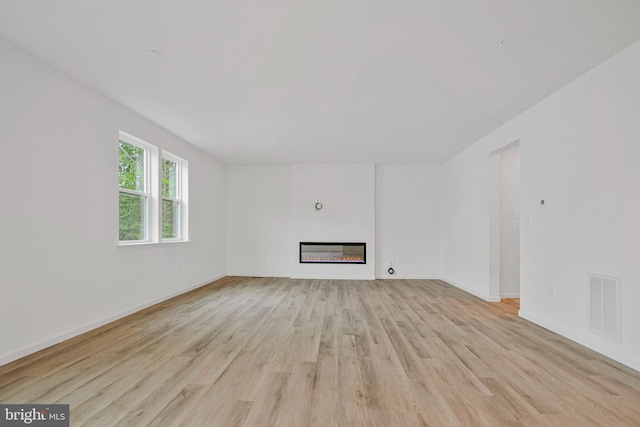 18 Aspen Dr, North East, MD 21901 - unfurnished living room with light wood finished floors, a glass covered fireplace, and baseboards