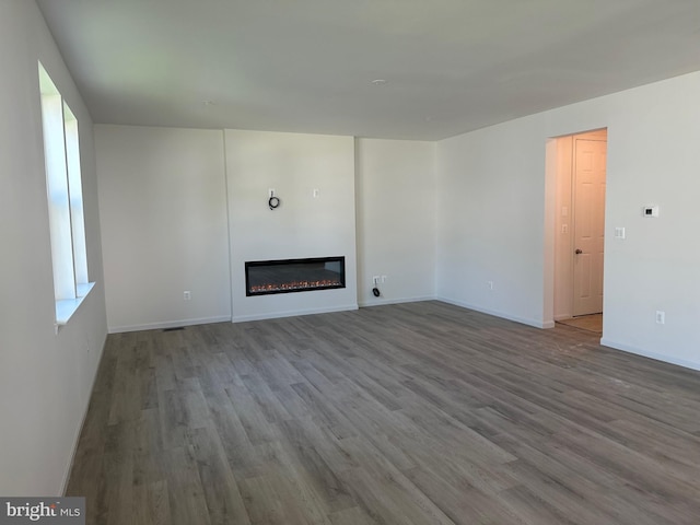 18 Aspen Dr, North East, MD 21901 - unfurnished living room featuring a glass covered fireplace, wood finished floors, and baseboards