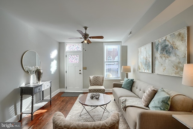 living room featuring dark wood-type flooring and ceiling fan