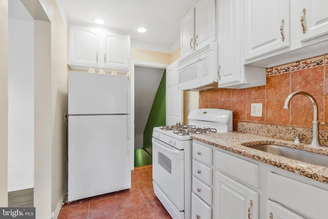 kitchen with sink, light stone counters, light tile patterned floors, white appliances, and white cabinets