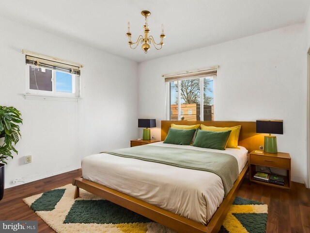 bedroom featuring dark hardwood / wood-style floors and an inviting chandelier