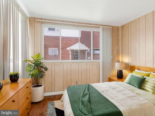 bedroom featuring hardwood / wood-style floors and wood walls