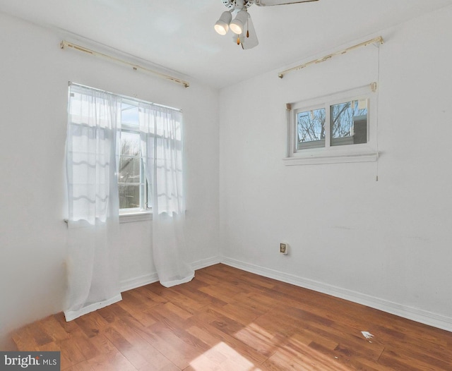 empty room featuring ceiling fan, light hardwood / wood-style floors, and a wealth of natural light