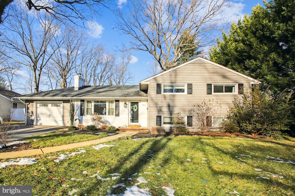 split level home with a garage and a front yard