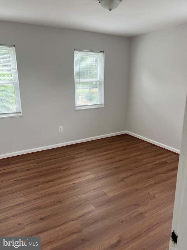 unfurnished room with dark wood-type flooring and a healthy amount of sunlight