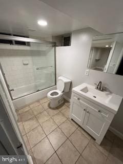 full bathroom featuring enclosed tub / shower combo, vanity, toilet, and tile patterned flooring