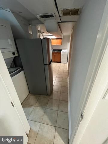 interior space featuring light tile patterned flooring, stainless steel fridge, and white stove