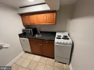 kitchen with white appliances, sink, and light tile patterned floors