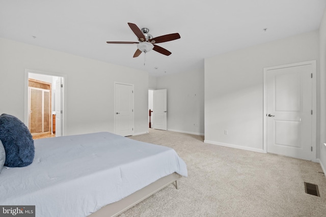 bedroom with ceiling fan, ensuite bathroom, and light carpet