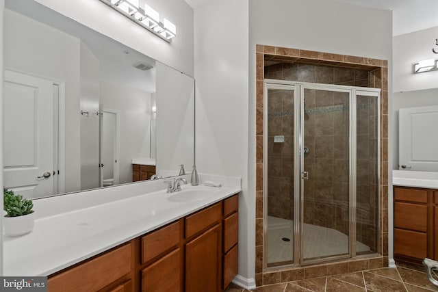 bathroom featuring tile patterned flooring, vanity, and a shower with door