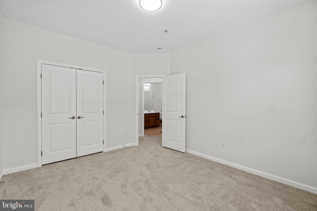 unfurnished bedroom with light carpet and a closet