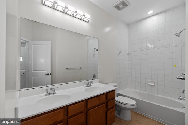 full bathroom featuring tiled shower / bath, tile patterned floors, toilet, and vanity