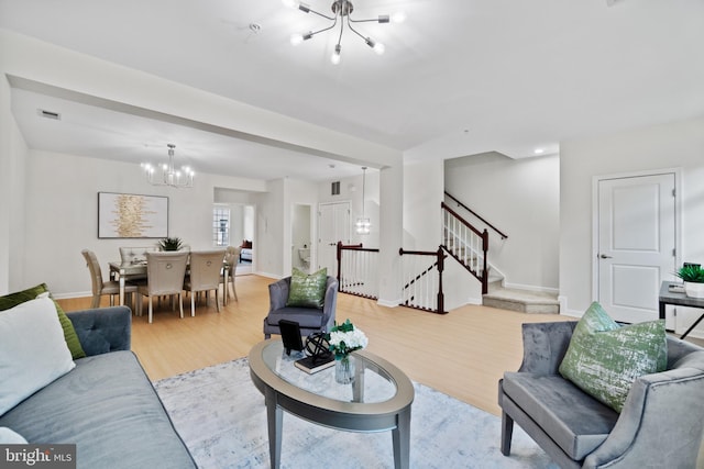 living room featuring a notable chandelier and light hardwood / wood-style flooring