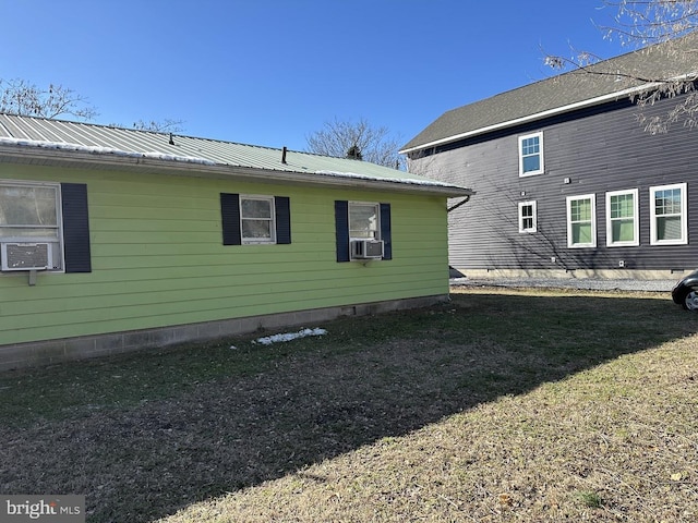 view of side of property featuring cooling unit and a yard