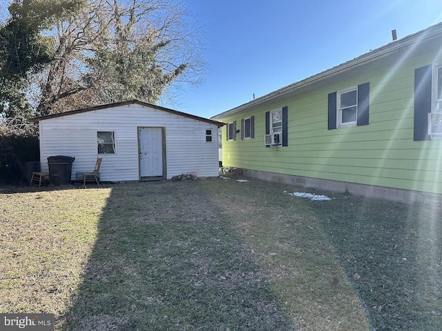 back of property with cooling unit and a yard