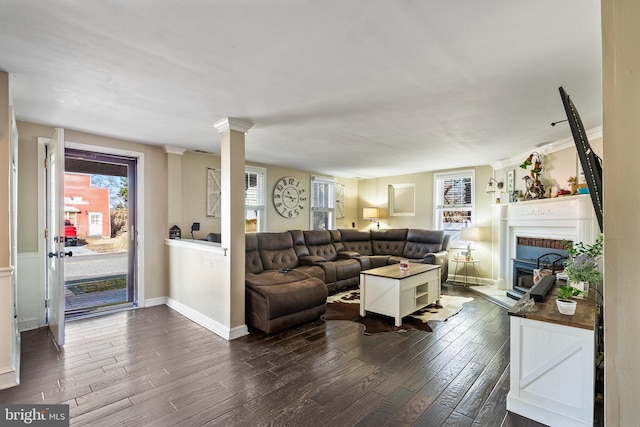 living room with dark hardwood / wood-style floors and ornate columns