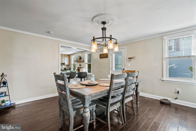 dining area featuring crown molding, dark hardwood / wood-style floors, and a chandelier