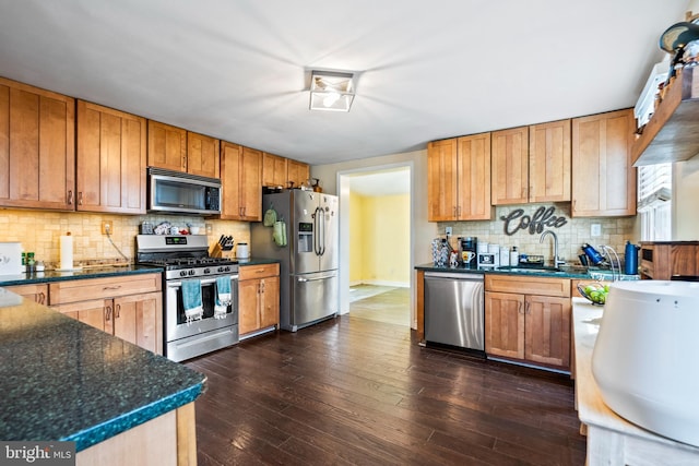 kitchen with sink, decorative backsplash, dark hardwood / wood-style floors, and appliances with stainless steel finishes