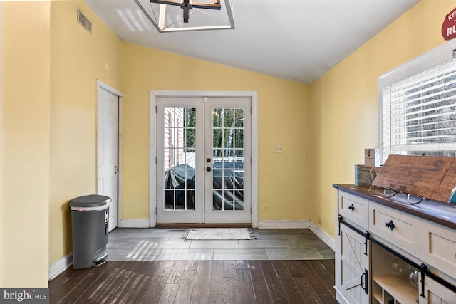 entryway featuring vaulted ceiling, dark wood-type flooring, and french doors