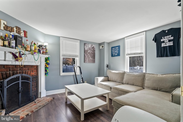 living room featuring dark hardwood / wood-style flooring and a brick fireplace