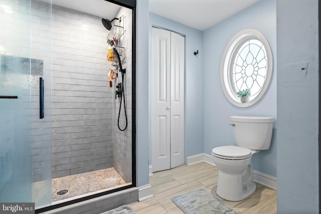 bathroom featuring tiled shower and toilet