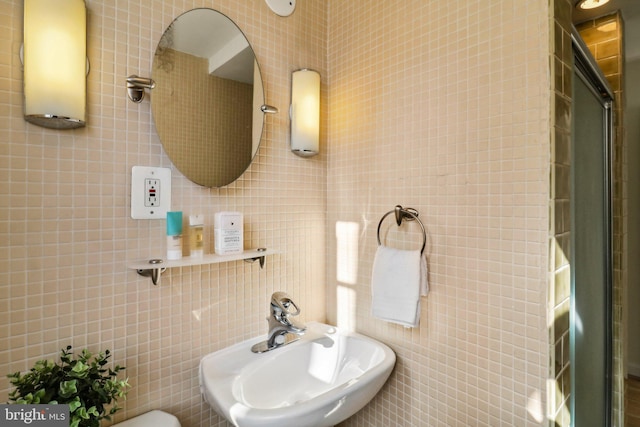 bathroom with tile walls and sink