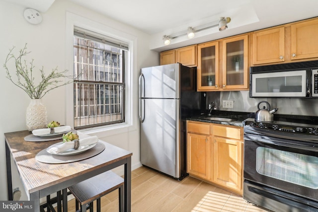 kitchen featuring dark stone countertops, sink, and stainless steel appliances