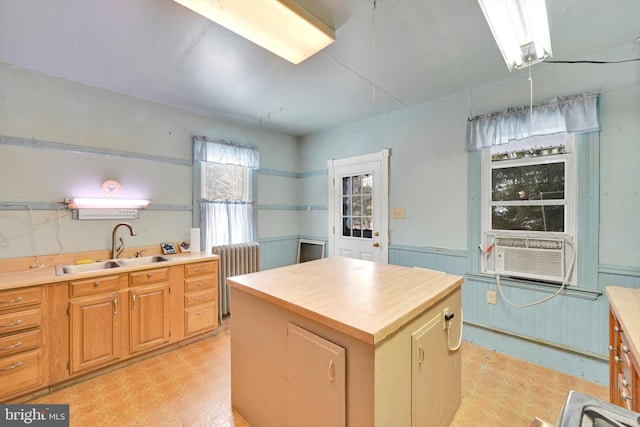 kitchen with cooling unit, radiator heating unit, sink, and a kitchen island