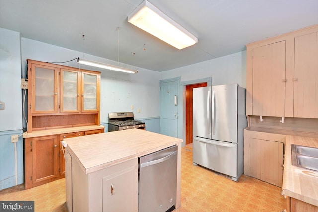 kitchen with stainless steel appliances, a kitchen island, and sink