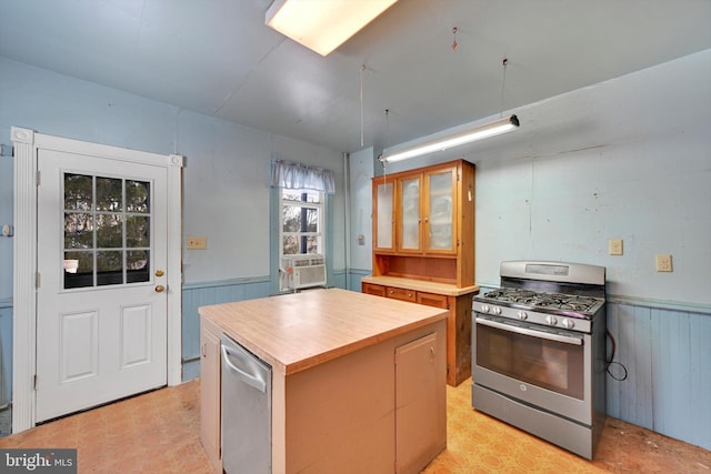 kitchen with cooling unit, wood counters, gas stove, and a kitchen island