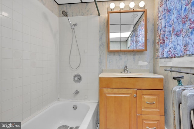 bathroom with tiled shower / bath and vanity