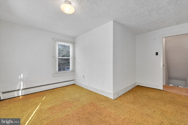 carpeted empty room featuring a textured ceiling and baseboard heating