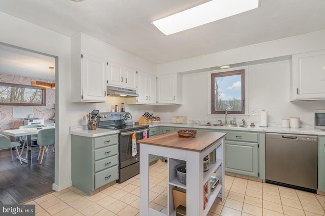 kitchen featuring light tile patterned floors, appliances with stainless steel finishes, sink, and white cabinets