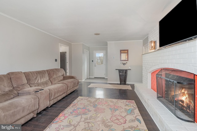 living room with dark hardwood / wood-style flooring, crown molding, and a fireplace