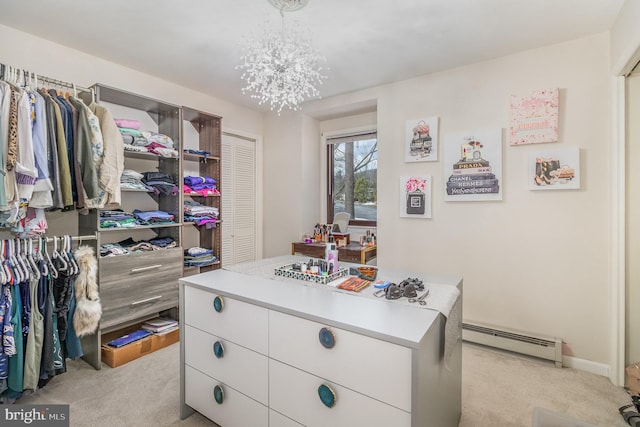 walk in closet featuring an inviting chandelier, a baseboard radiator, and light colored carpet