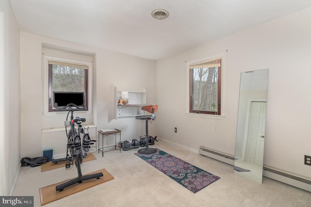 workout area featuring a baseboard heating unit and carpet floors