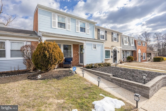 townhome / multi-family property featuring a front lawn