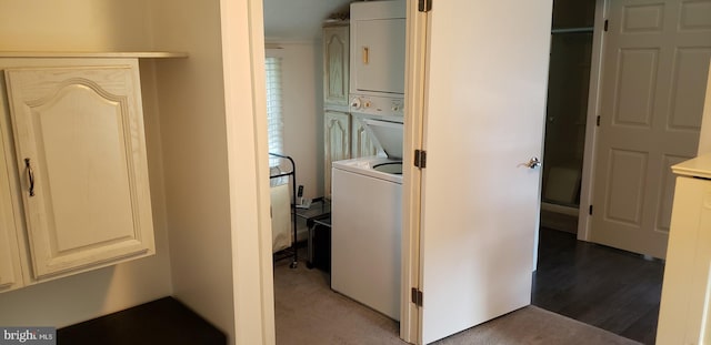 laundry area featuring stacked washer and clothes dryer and hardwood / wood-style floors