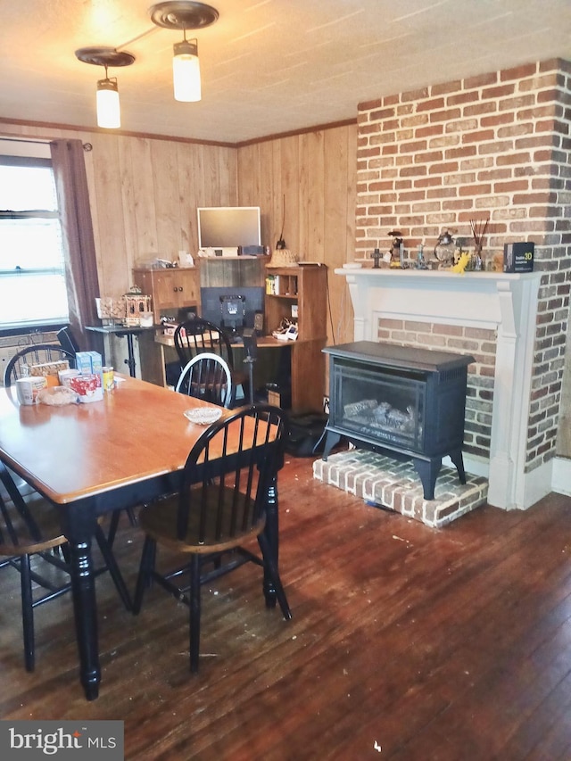 dining space featuring wooden walls and dark hardwood / wood-style flooring