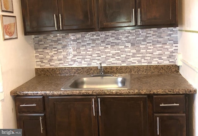 kitchen featuring tasteful backsplash, dark brown cabinets, and sink