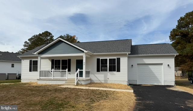 single story home with a porch, a garage, and a front yard