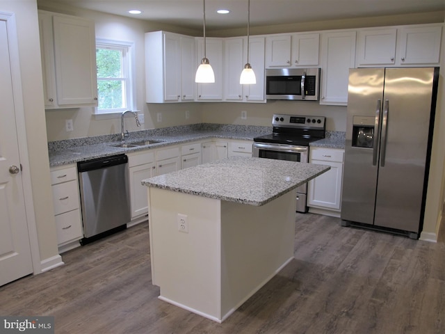 kitchen with sink, decorative light fixtures, a kitchen island, stainless steel appliances, and white cabinets